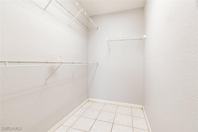 walk in closet with light tile patterned floors