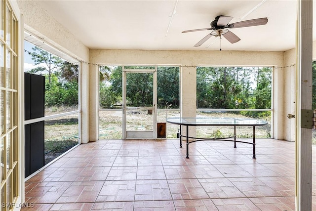 unfurnished sunroom with ceiling fan