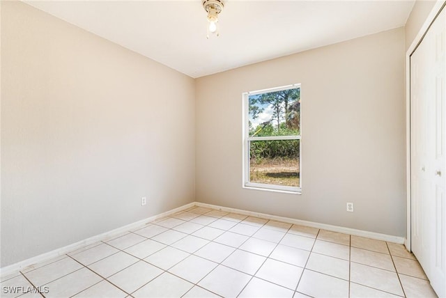 unfurnished room with baseboards and light tile patterned floors
