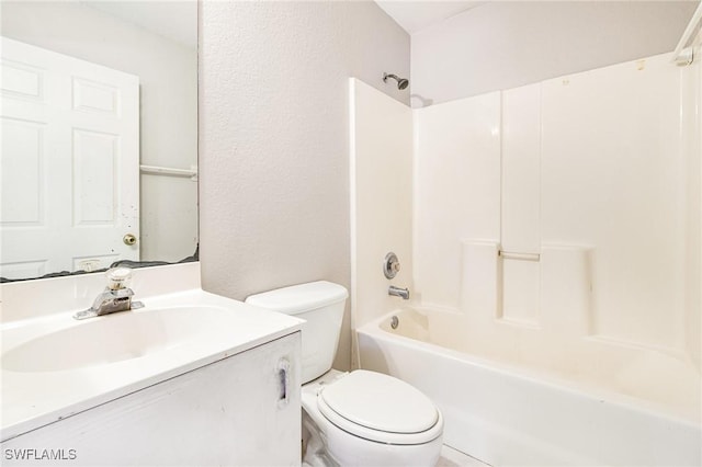 full bathroom featuring toilet,  shower combination, vanity, and a textured wall