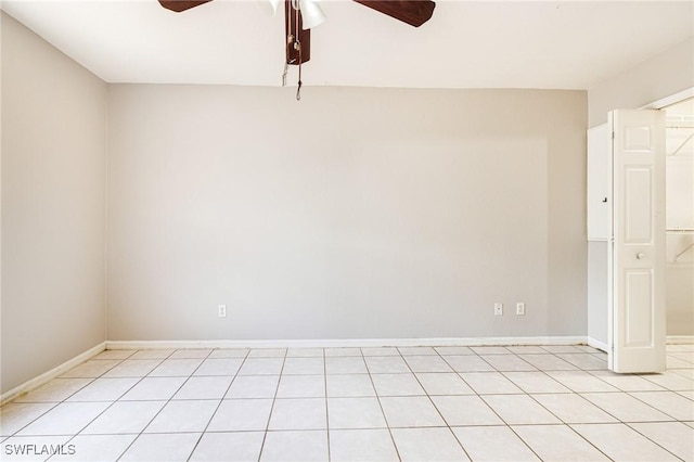 spare room featuring ceiling fan, baseboards, and light tile patterned floors