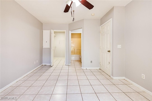 unfurnished bedroom with a closet, a ceiling fan, baseboards, and a walk in closet