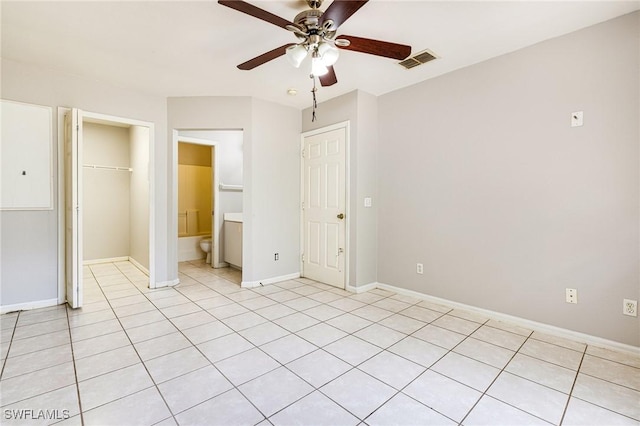 unfurnished bedroom featuring a closet, baseboards, visible vents, light tile patterned flooring, and a spacious closet