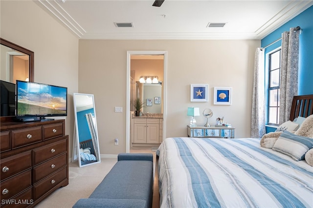 bedroom with visible vents, crown molding, ensuite bath, and light carpet