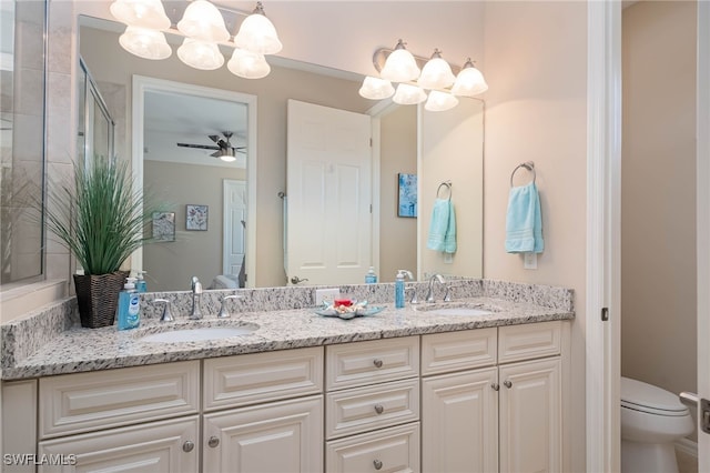 bathroom with a sink, toilet, and double vanity