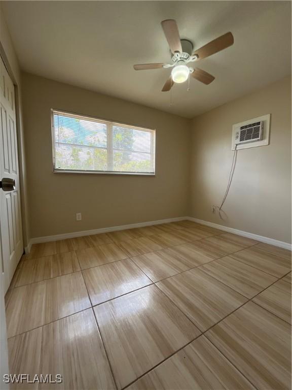 508 Wyoming Rd, Lehigh Acres, FL 33936 - unfurnished bedroom featuring an AC wall unit, a closet, baseboards, and ceiling fan