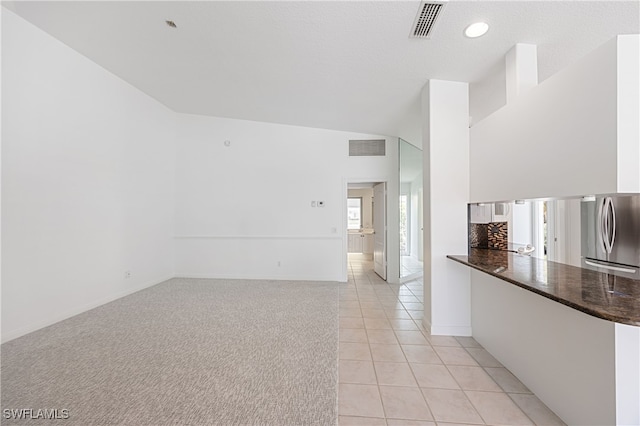 4788 San Carlo Ct, Naples, FL 34109 - spare room featuring light tile patterned floors, vaulted ceiling, light colored carpet, and recessed lighting