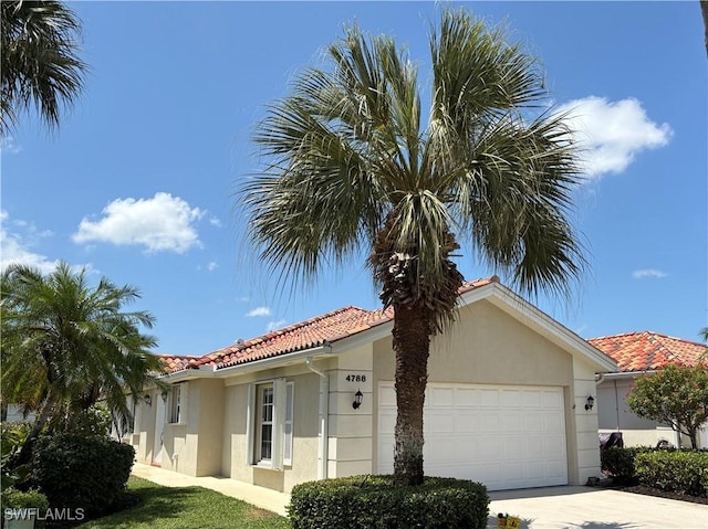 4788 San Carlo Ct, Naples, FL 34109 - mediterranean / spanish house featuring stucco siding, a garage, driveway, and a tile roof