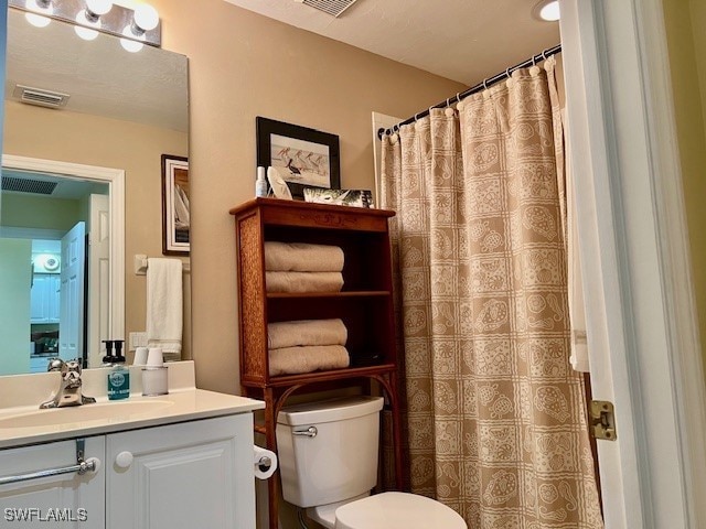 bathroom with vanity, a shower with curtain, toilet, and visible vents