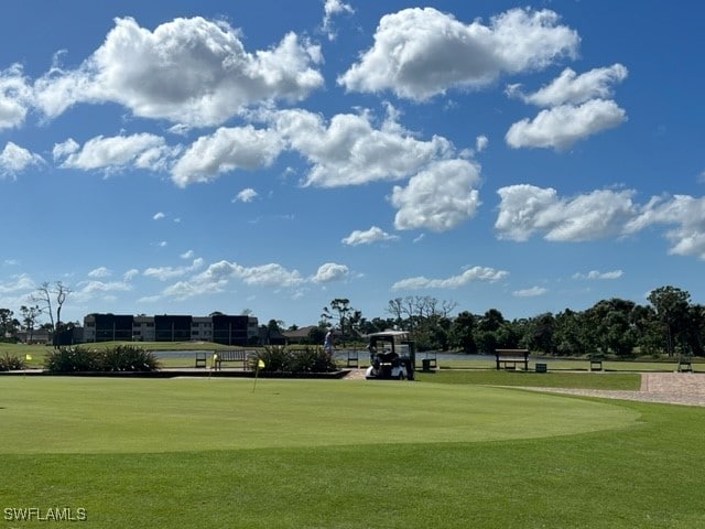 view of home's community featuring view of golf course and a yard