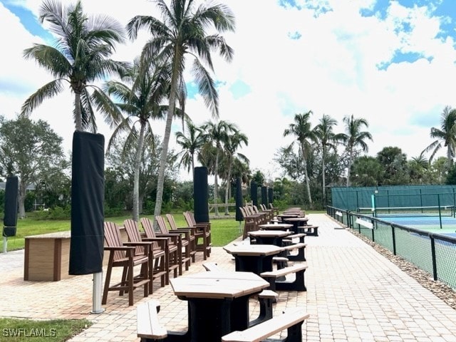 surrounding community featuring a tennis court and fence