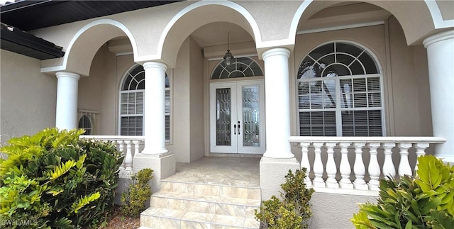 3787 Whippoorwill Ct, Punta Gorda, FL 33950 - doorway to property featuring french doors, covered porch, and stucco siding