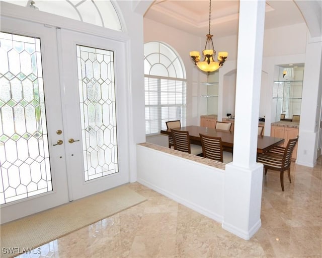 3787 Whippoorwill Ct, Punta Gorda, FL 33950 - foyer entrance featuring french doors, arched walkways, baseboards, a raised ceiling, and a chandelier