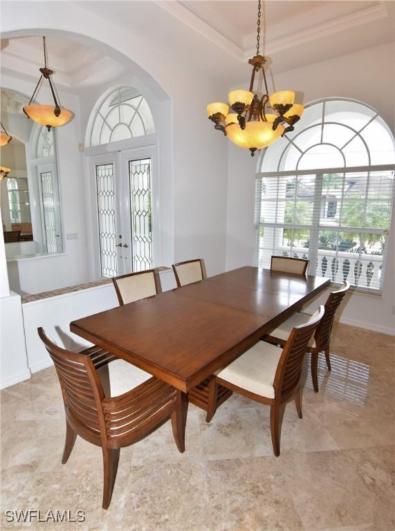 3787 Whippoorwill Ct, Punta Gorda, FL 33950 - dining area with an inviting chandelier, crown molding, a tray ceiling, and french doors