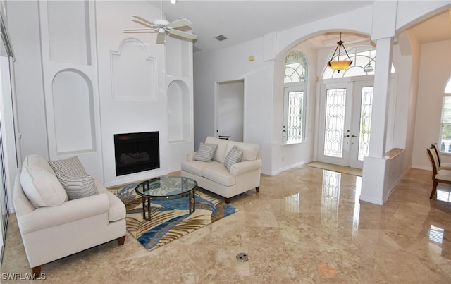 3787 Whippoorwill Ct, Punta Gorda, FL 33950 - living area featuring a fireplace, arched walkways, french doors, marble finish floor, and a ceiling fan
