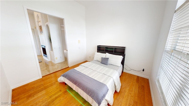 3787 Whippoorwill Ct, Punta Gorda, FL 33950 - bedroom featuring arched walkways, baseboards, and light wood-style floors