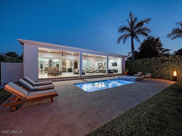 view of pool featuring fence, a pool with connected hot tub, an outdoor hangout area, a patio area, and a ceiling fan