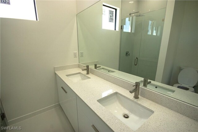3610 22nd St SW, Lehigh Acres, FL 33976 - bathroom featuring double vanity, a sink, toilet, and a shower stall