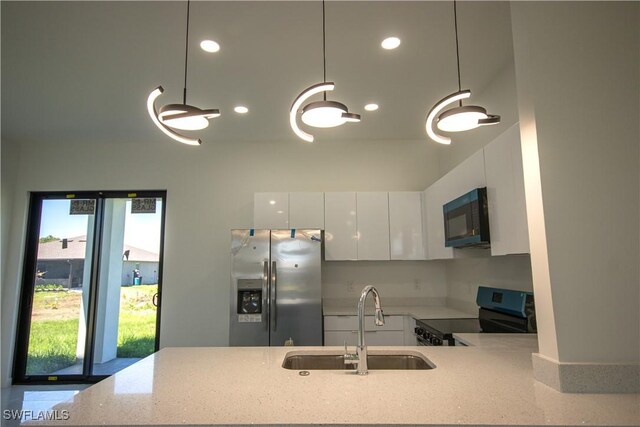 3610 22nd St SW, Lehigh Acres, FL 33976 - kitchen featuring recessed lighting, white cabinetry, light stone counters, a sink, and stainless steel appliances