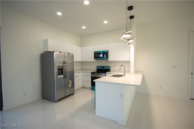 3610 22nd St SW, Lehigh Acres, FL 33976 - kitchen with a peninsula, light countertops, white cabinetry, a sink, and appliances with stainless steel finishes