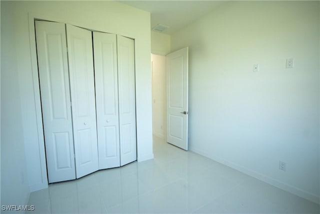 3610 22nd St SW, Lehigh Acres, FL 33976 - unfurnished bedroom with baseboards, tile patterned flooring, and a closet