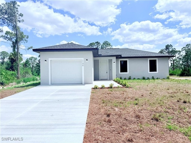 view of front of property with an attached garage, driveway, and stucco siding