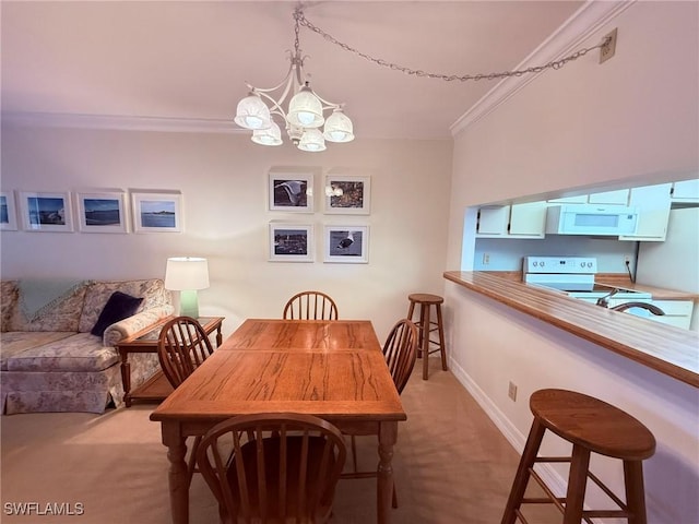 dining area featuring crown molding, baseboards, an inviting chandelier, and light carpet