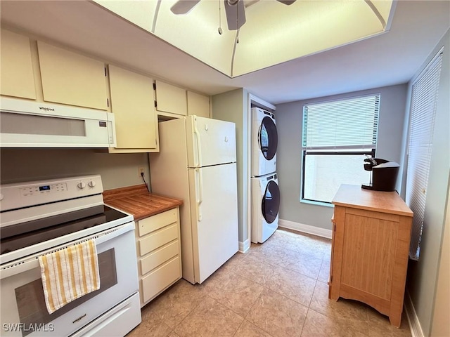 kitchen with ceiling fan, light tile patterned floors, baseboards, stacked washer and clothes dryer, and white appliances