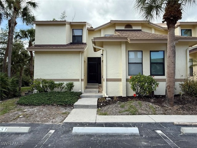 view of front facade with uncovered parking and stucco siding