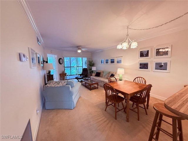 dining space featuring baseboards, ornamental molding, light carpet, and ceiling fan with notable chandelier