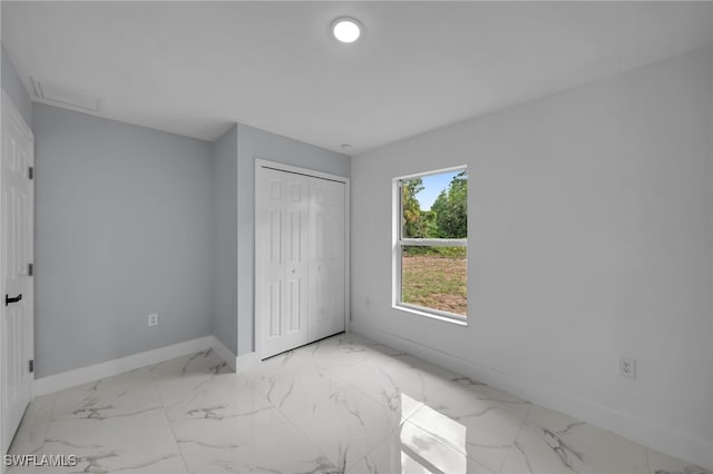 755 Milano Ave S, Lehigh Acres, FL 33974 - unfurnished bedroom with visible vents, a closet, marble finish floor, baseboards, and attic access