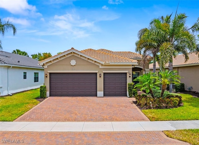 mediterranean / spanish home with an attached garage, a front lawn, stucco siding, decorative driveway, and a tiled roof