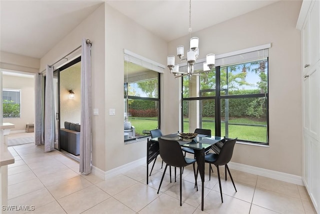 dining room featuring baseboards, light tile patterned floors, and a chandelier