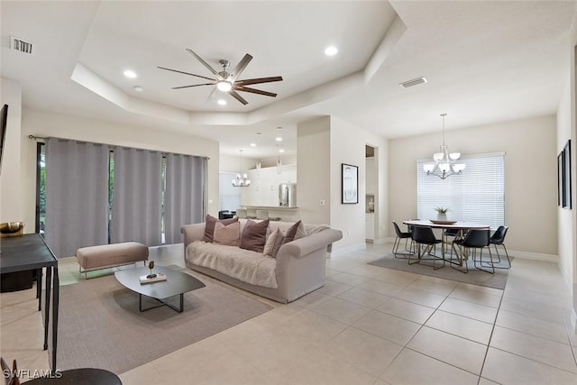 living room with visible vents, a raised ceiling, and a wealth of natural light