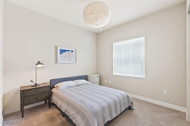 bedroom featuring light colored carpet and baseboards