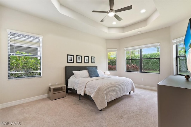 bedroom with recessed lighting, baseboards, light colored carpet, and a raised ceiling