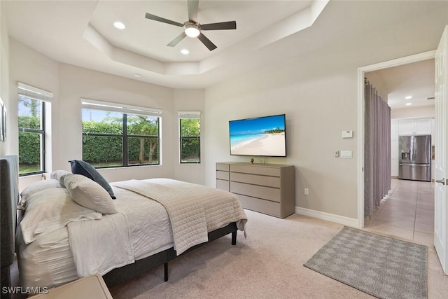 bedroom featuring light carpet, baseboards, recessed lighting, a raised ceiling, and stainless steel fridge with ice dispenser