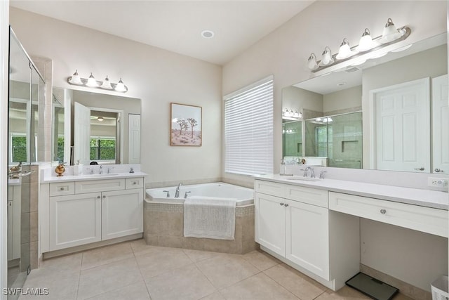 full bathroom featuring a sink, a bath, a stall shower, and two vanities