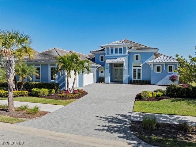6250 Lightbourn Way, Naples, FL 34113 - mediterranean / spanish-style house featuring an attached garage, stucco siding, decorative driveway, french doors, and a tiled roof