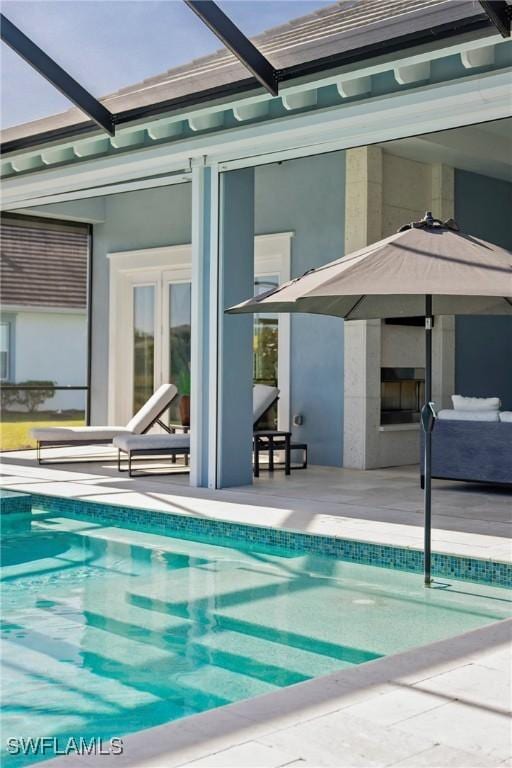 back of property with a lanai, a patio area, and an outdoor pool