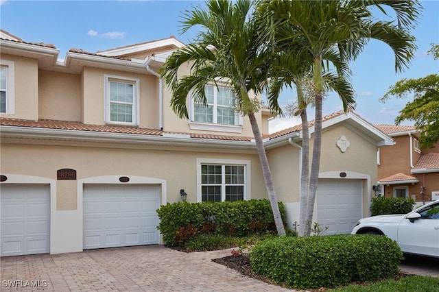 view of front of property with a garage, stucco siding, decorative driveway, and a tile roof