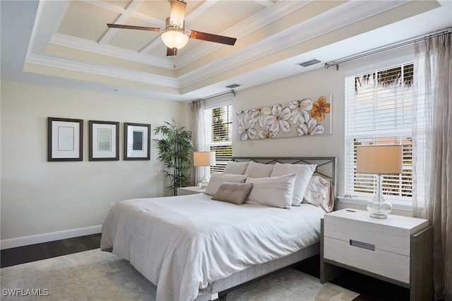 bedroom featuring a ceiling fan, baseboards, dark wood-style floors, ornamental molding, and a tray ceiling