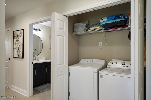 washroom with laundry area, baseboards, light tile patterned floors, and washer and dryer