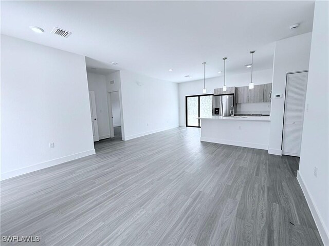 5010 Day Ln, Labelle, FL 33935 - unfurnished living room featuring visible vents, baseboards, light wood-type flooring, recessed lighting, and a sink