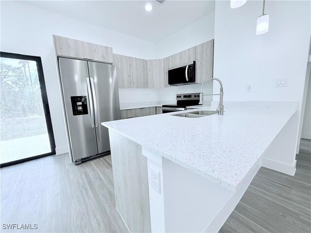 5010 Day Ln, Labelle, FL 33935 - kitchen featuring appliances with stainless steel finishes, modern cabinets, light wood-type flooring, a sink, and a peninsula