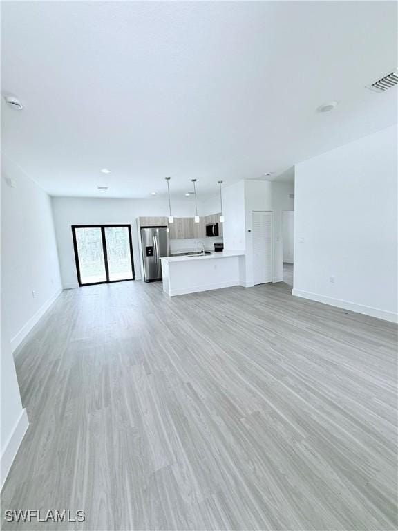 5010 Day Ln, Labelle, FL 33935 - unfurnished living room with baseboards, visible vents, and light wood-type flooring