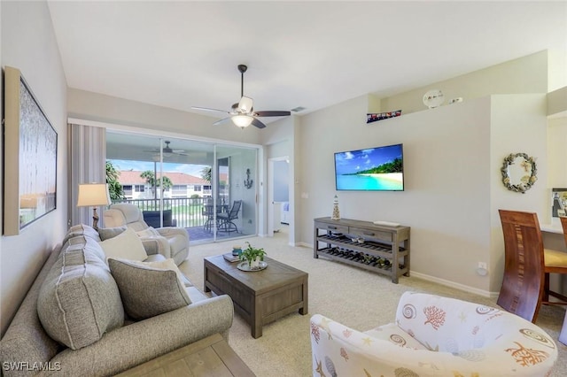 living room with a ceiling fan, baseboards, and carpet