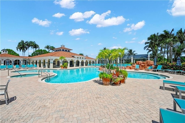 pool featuring a community hot tub and a patio area