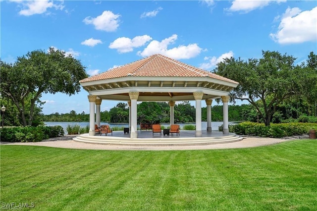 view of home's community with a gazebo, a water view, and a lawn