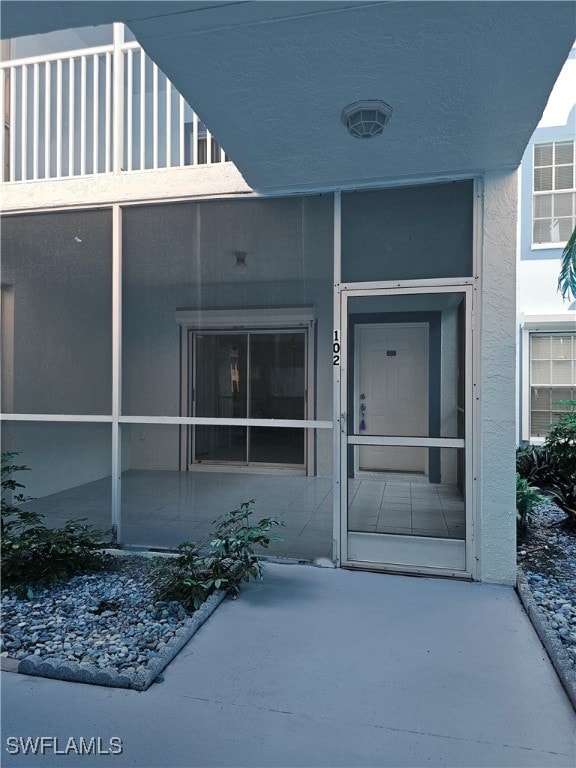 6025 Chardonnay Ln Unit 102, Naples, FL 34119 - doorway to property featuring stucco siding